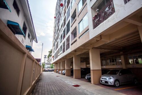 rząd budynków z samochodami zaparkowanymi na ulicy w obiekcie Galare Thong Tower w mieście Chiang Mai