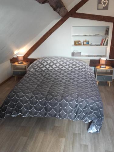 a bedroom with a large bed in a attic at Chambre d'hôtes La Guéjaillière in Beaumont-Pied-de-Boeuf