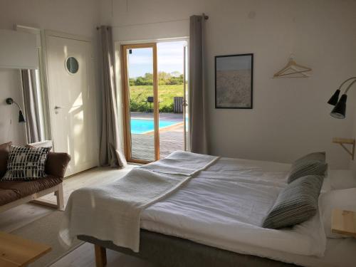 a bedroom with a bed and a door to a pool at Bodelssons by the Sea in Tosteberga