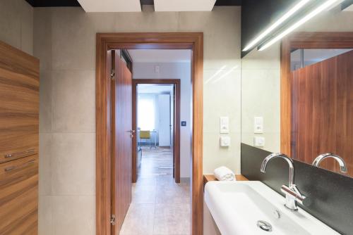 een badkamer met een wastafel en een spiegel bij Apartament Kalinowo Golf - salon z opcją spania, kuchnia i 2 sypialnie, 1-6 osób in Niesulice