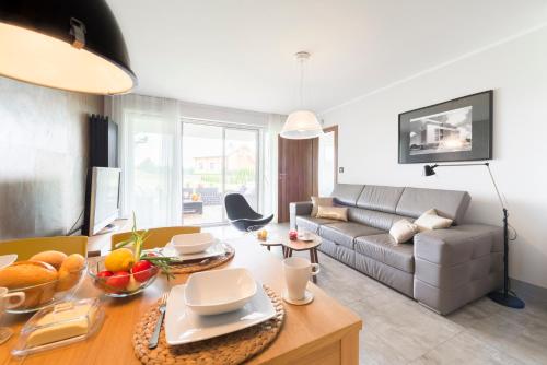 ein Wohnzimmer mit Couch und Tisch in der Unterkunft Apartament Kalinowo Golf - salon z opcją spania, kuchnia i 2 sypialnie, 1-6 osób in Niesulice