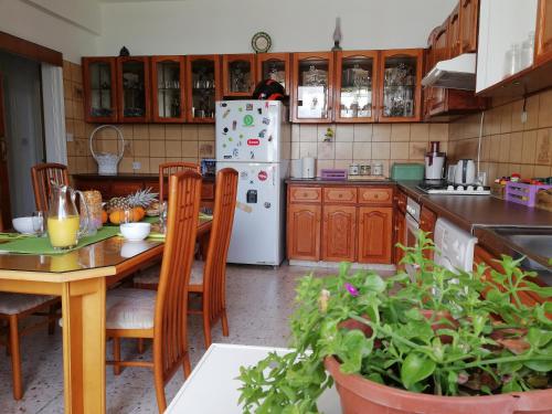 a kitchen with a table and a white refrigerator at Family Nest In The Heart Of Limassol in Limassol