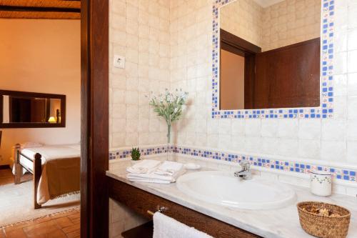 a bathroom with a sink and a bed in a room at Casa de Cacela in Vila Nova de Cacela