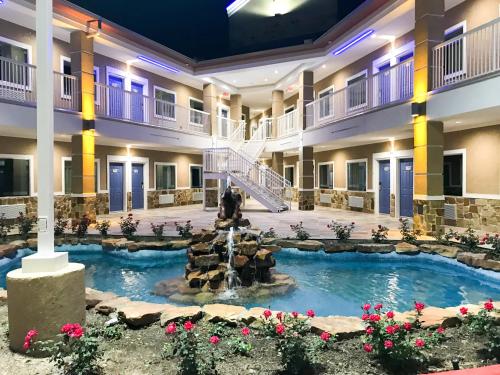 a hotel with a fountain in the middle of a courtyard at Motel 6-Houston, TX - North in Houston