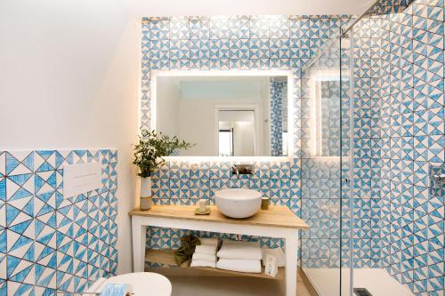 a bathroom with a blue and white tiled wall at MelRose Sorrento in Sorrento