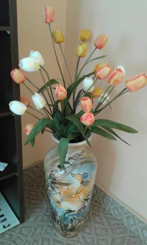 a vase with pink and white flowers in it at Семеен хотел Пауталия in Kyustendil