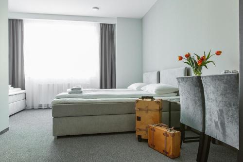 sypialnia z łóżkiem i wazonem z kwiatami w obiekcie Gdynia Centrum w mieście Gdynia