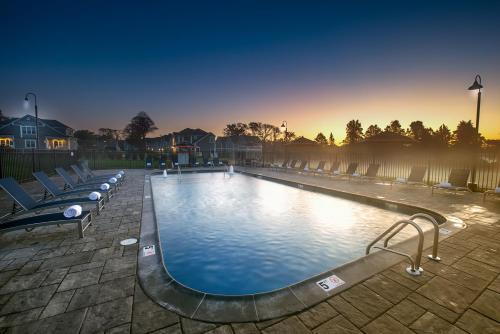 uma grande piscina com cadeiras e o pôr do sol ao fundo em The East Island Reserve Hotel em Middletown