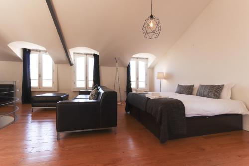 um quarto com uma cama, um sofá e uma cadeira em Santa Catarina Stylish by Homing em Lisboa
