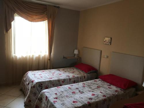 Duas camas num quarto com uma janela em Roy Home em Acerra