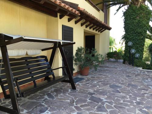 a patio with a bench next to a house at Poggio Delle Palme in Campobello di Licata
