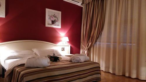 a bedroom with a bed with a red wall at Hotel President in Chianciano Terme