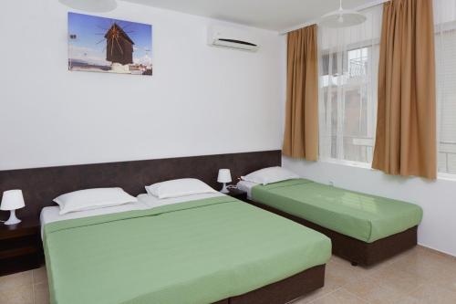 a bedroom with two beds and a window at Complex Moskoyani in Nesebar