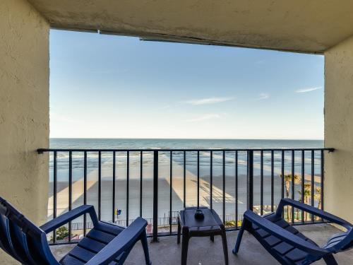 a balcony with chairs and a view of the beach at Beachside Hotel - POOL IS OPEN! in Daytona Beach