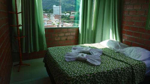 a teddy bear sitting on a bed in a bedroom at Pousada Monte Serrat in Bonito