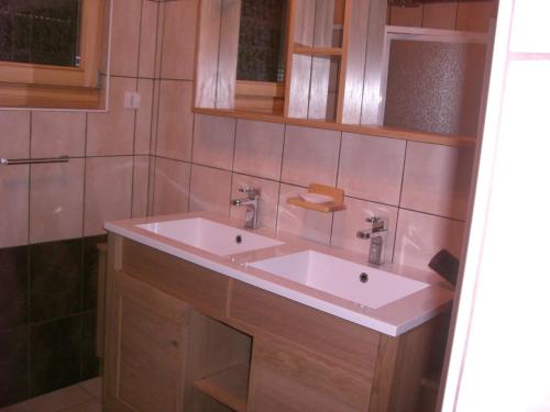 a bathroom with a white sink and wooden cabinets at Chalets les Marcels in La Bresse