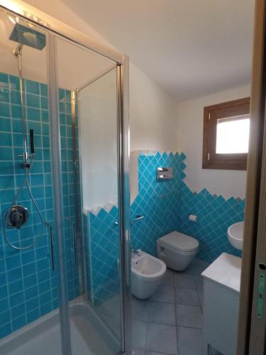 a bathroom with a shower and a toilet and a sink at Casa Degli Ulivi in Cala Liberotto