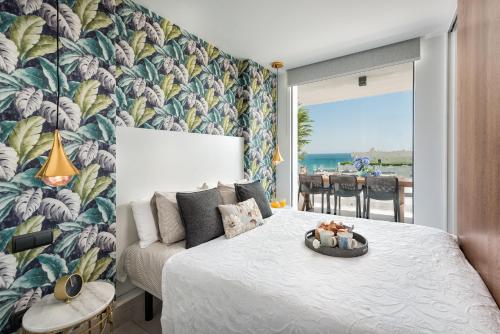 - une chambre avec un lit et du papier peint tropical dans l'établissement Marbella Luxury Frontline Beach W Panoramic View, à Marbella