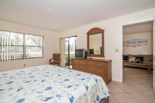 a bedroom with a bed and a tv and a mirror at Shorewalk 2 Bedroom 2 Bathroom Near IMG And Bradenton Beach in Bradenton
