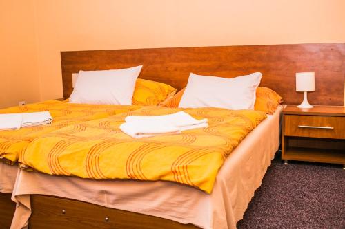 a bedroom with a large bed with two towels on it at Penzion Fako in Liptovský Mikuláš