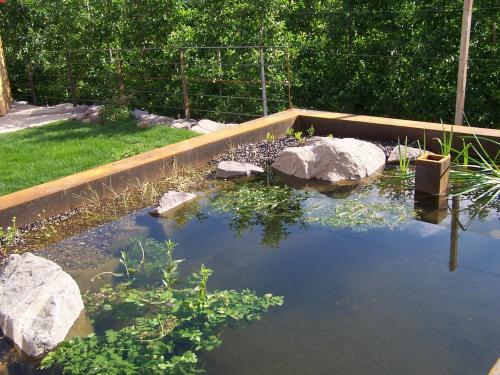 a garden with a pond with rocks and water at St. Ulrichhof in Lana