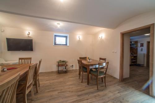 Un comedor con mesa y sillas y un televisor. en Pernštejnův statek, en Dívčí Kopy