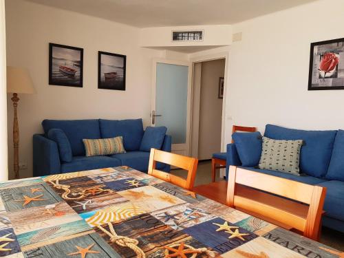 - un salon avec des canapés bleus et une table dans l'établissement Sadurni Apartaments, à Palamós