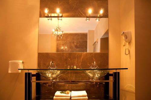 a bathroom with a glass sink and a mirror at Hotel Kolegiacki in Poznań