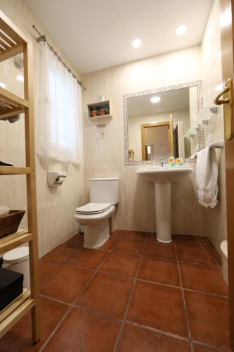 uma casa de banho com um WC, um lavatório e um espelho. em Cozy Apartment City Hall em Alicante