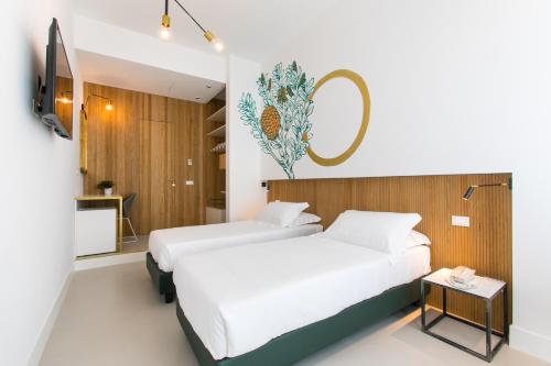 a bedroom with two beds and a tv and a table at Horti 14 Borgo Trastevere Hotel in Rome