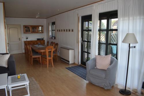 a living room with a table and chairs and a kitchen at Gönnerbude Fehmarn in Fehmarn