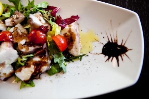 a white plate of food with a salad on it at Hotel La Cartiera in Vignola