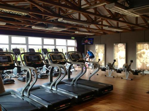 a gym with rows of tread machines in a room at Bowfield Hotel and Spa in Howwood