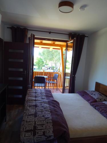 a bedroom with a bed and a sliding glass door at Penzion U Raka in Pasohlávky
