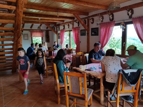 a group of people sitting at tables in a restaurant at Etno domaćinstvo Milenković in Despotovac