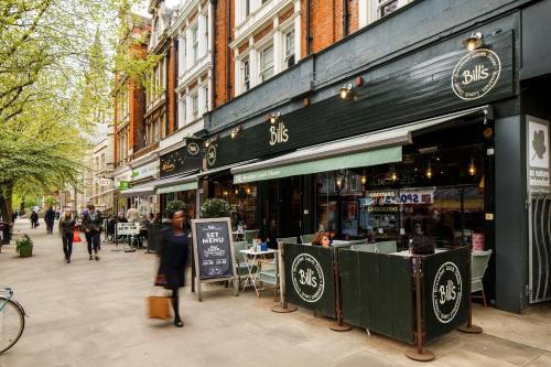 a woman walking down a street in front of a store at ibis Styles London Ealing in London