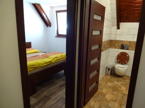 Penzion U Raka في باسوهلافكي: غرفة نوم صغيرة بها سرير ومرحاض