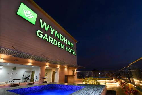a hotel with a swimming pool in front of a building at Wyndham Garden Barranquilla in Barranquilla