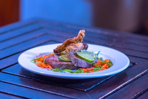 a plate of food with meat and vegetables on a table at Holiday Haven Ukulhas in Ukulhas