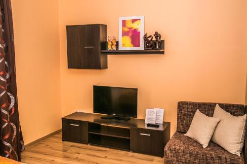 a living room with a tv and a chair at Penzion Fako in Liptovský Mikuláš