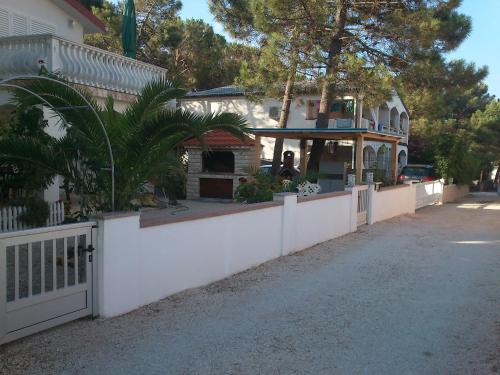 a white fence in front of a house at Apartmani Luka in Vir