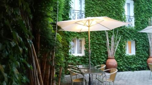 a table and chairs with an umbrella on a patio at Travelers by Rio NaturAL in Vila Nova de Milfontes