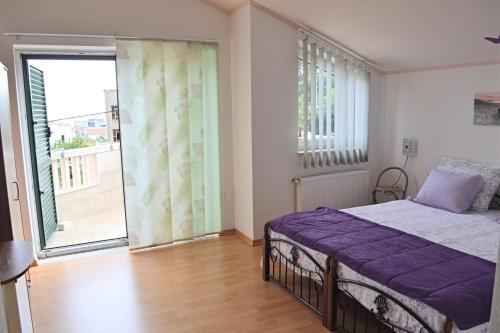 a bedroom with a bed and a large window at Apartments Dragun in Podstrana