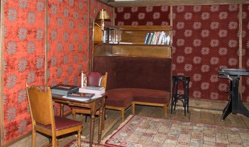 a room with a piano and a desk and chairs at Grenlanda in Ulanów