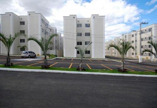 a parking lot with palm trees in front of a building at Apartamento no Dalas Park Residencial in Campina Grande