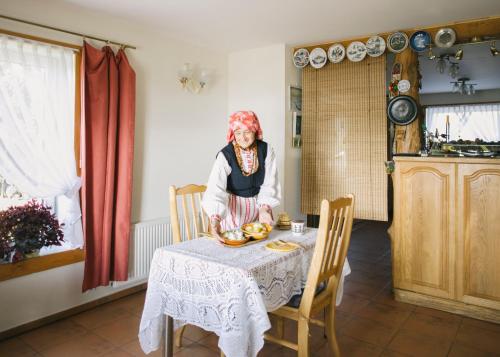 una persona sentada en una mesa en una cocina en Jurodis, en Jurbarkas