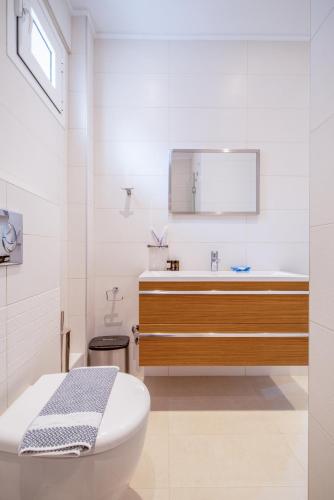 a white bathroom with a sink and a toilet at Kamis Suite in Neos Marmaras