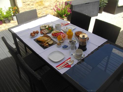 a table with a breakfast of food and orange juice at Les Halles Chambre D'hôtes in Verteuil-sur-Charente