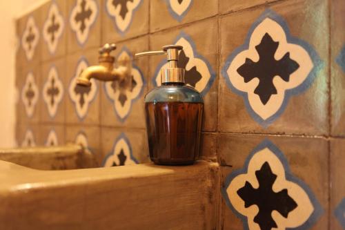 a bottle of soap is sitting on a bathroom sink at Hostal La Tortuga Booluda in León