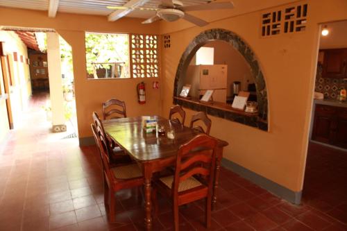 a dining room with a wooden table and chairs at Hostal La Tortuga Booluda in León